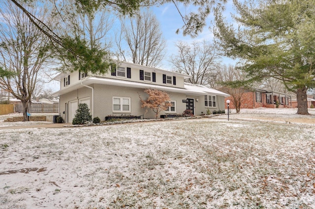 view of front facade featuring brick siding and fence