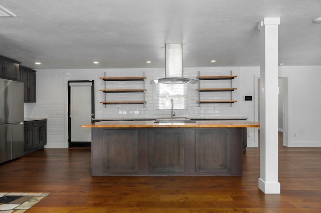 kitchen featuring island exhaust hood, wood counters, open shelves, and freestanding refrigerator