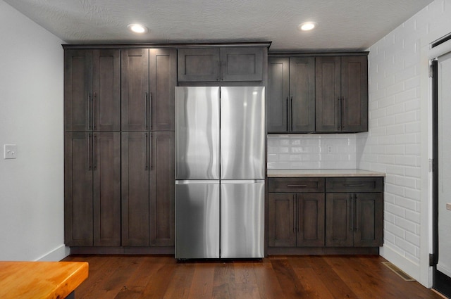 kitchen featuring dark wood-style floors, light countertops, dark brown cabinets, and freestanding refrigerator