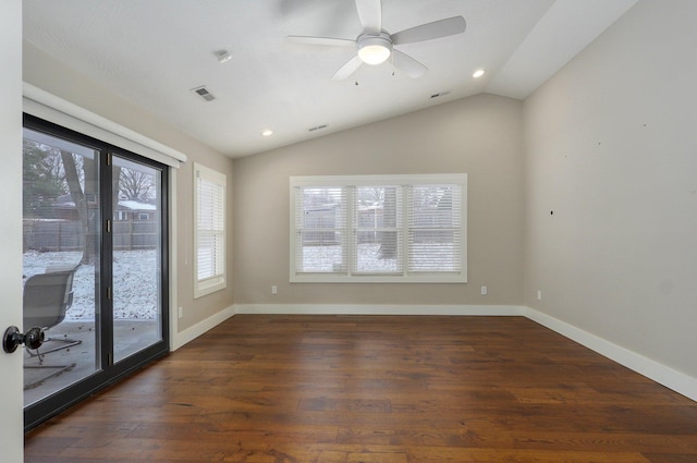 empty room featuring lofted ceiling, baseboards, visible vents, and dark wood-type flooring