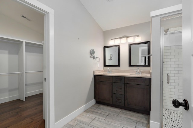 bathroom with visible vents, vaulted ceiling, and a sink