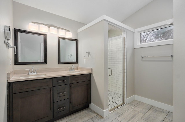 full bath with a shower stall, baseboards, and a sink