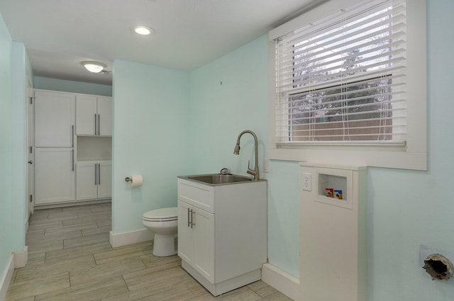 bathroom with recessed lighting, toilet, wood tiled floor, vanity, and baseboards