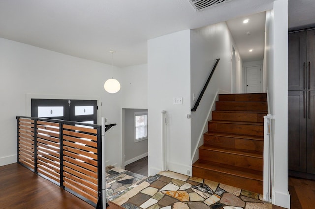 stairs featuring baseboards, visible vents, and wood finished floors