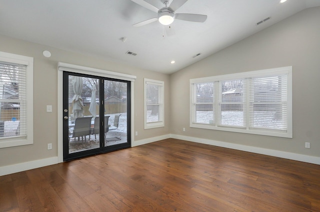 unfurnished room with dark wood-type flooring, visible vents, and vaulted ceiling