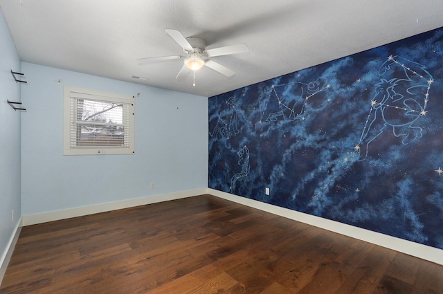 empty room with dark wood-style floors, baseboards, and a ceiling fan