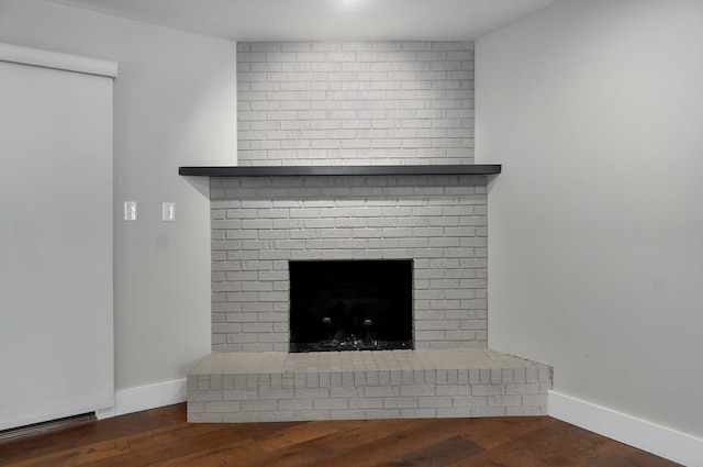 details with a brick fireplace, baseboards, and wood finished floors