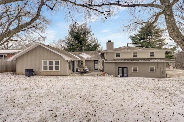 back of house featuring brick siding, a patio, a chimney, central AC unit, and fence