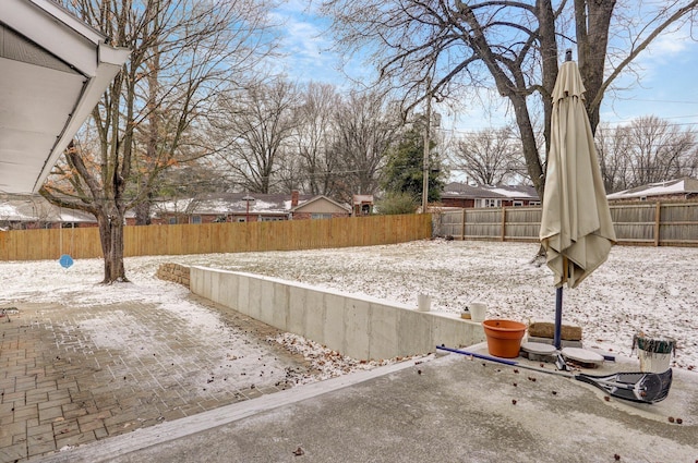 yard covered in snow featuring a fenced backyard and a patio