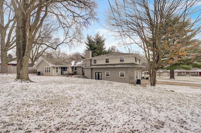 rear view of house featuring brick siding, fence, a chimney, and central air condition unit