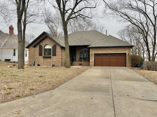 ranch-style home featuring a garage, concrete driveway, brick siding, and a shingled roof