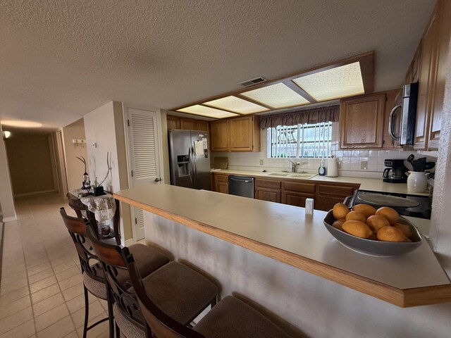 85 La Jolla Dr Unit 352-A, Lake Ozark, MO 65049 - kitchen with a peninsula, a breakfast bar area, stainless steel appliances, and light countertops
