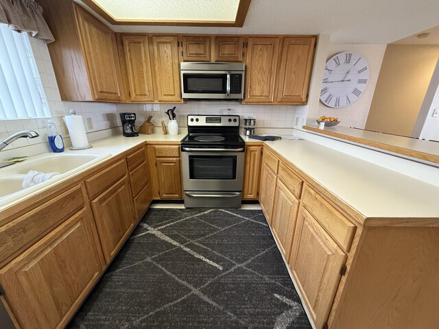 85 La Jolla Dr Unit 352-A, Lake Ozark, MO 65049 - kitchen with stainless steel appliances, light countertops, a sink, and tasteful backsplash