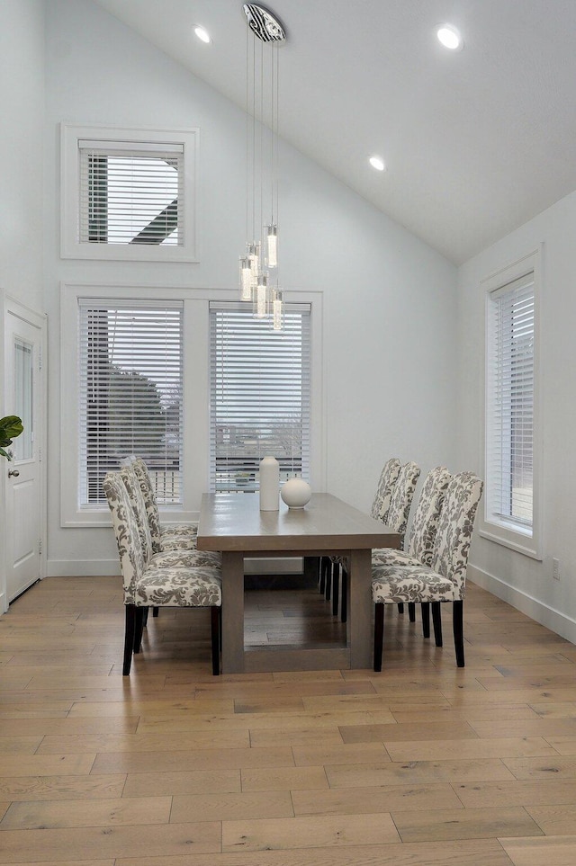 dining space with light wood-style floors, baseboards, high vaulted ceiling, and recessed lighting