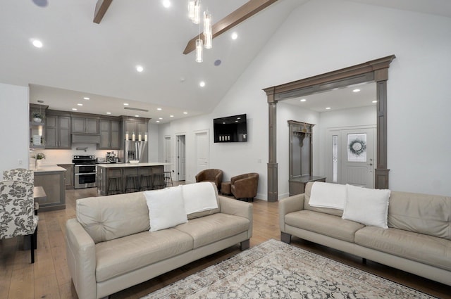 living room featuring high vaulted ceiling, beamed ceiling, recessed lighting, and light wood-style floors