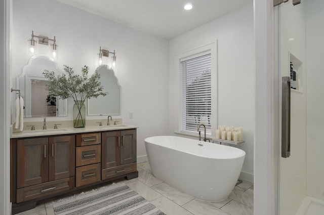 bathroom featuring baseboards, a freestanding bath, a sink, and double vanity