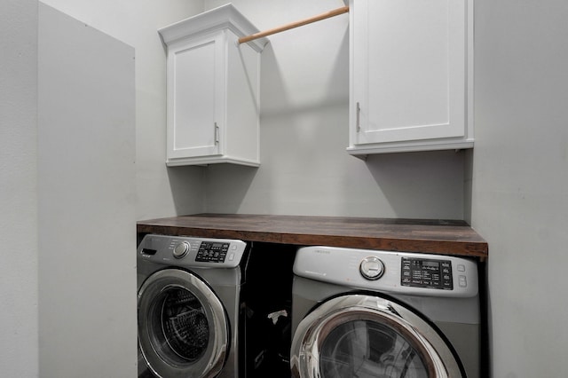 washroom featuring separate washer and dryer and cabinet space