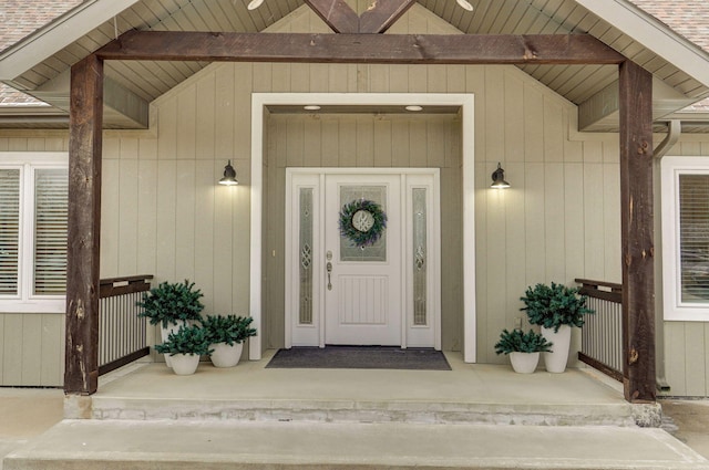 view of exterior entry featuring a shingled roof