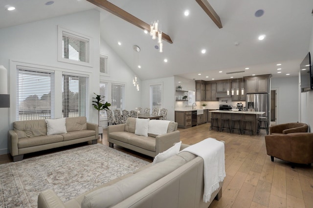 living area featuring high vaulted ceiling, recessed lighting, visible vents, and light wood-style flooring