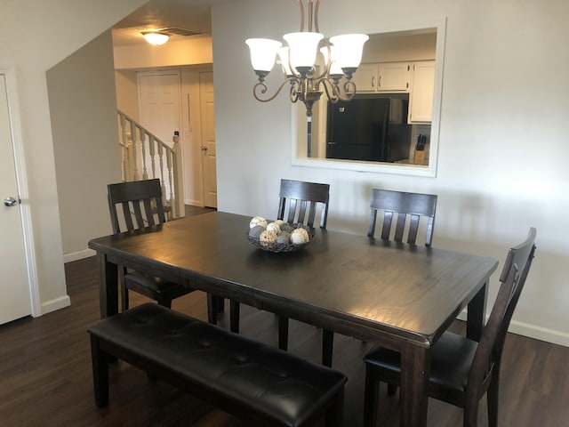 dining space with dark wood-type flooring, stairway, baseboards, and an inviting chandelier