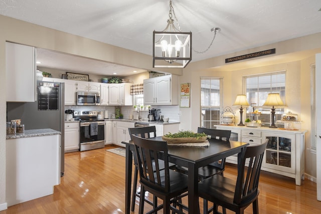 dining area with a chandelier and light wood-style floors