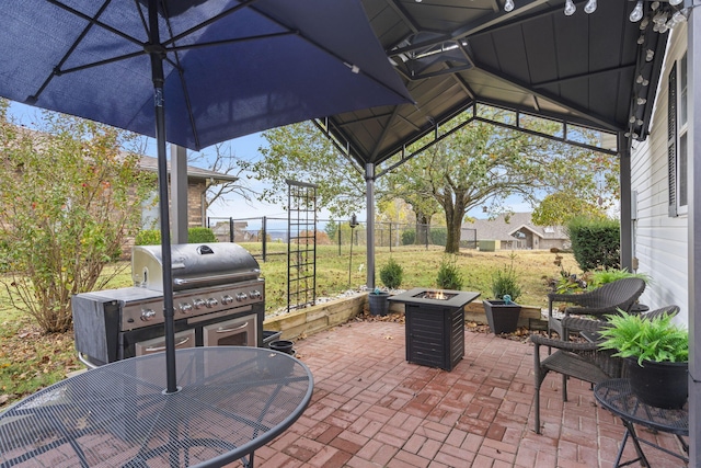 view of patio with a fenced backyard, a fire pit, and a gazebo