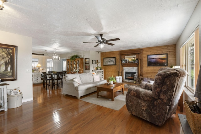 living room with a fireplace, a ceiling fan, dark wood finished floors, and a textured ceiling