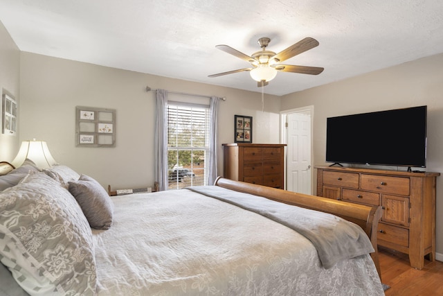 bedroom featuring ceiling fan, a textured ceiling, and wood finished floors