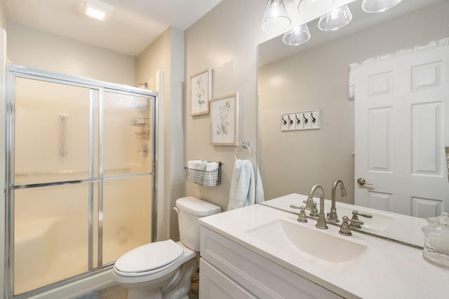 full bathroom with toilet, a shower stall, and vanity