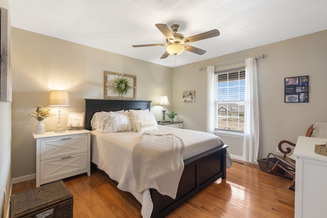 bedroom featuring visible vents, ceiling fan, baseboards, and wood finished floors