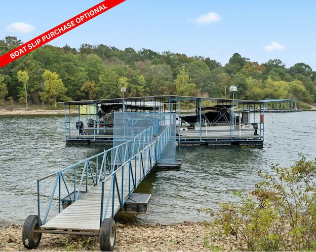 dock area with a water view, boat lift, and a forest view