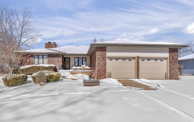 view of front of house featuring an attached garage, brick siding, and a chimney