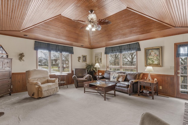 living room with a wainscoted wall, plenty of natural light, carpet, and wooden ceiling