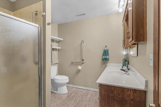 bathroom featuring visible vents, a shower stall, baseboards, toilet, and vanity