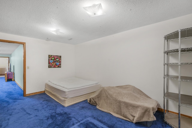 carpeted bedroom featuring a textured ceiling and baseboards