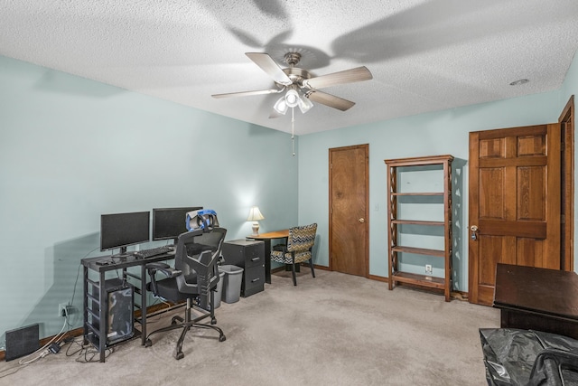 carpeted office space featuring baseboards, a textured ceiling, and a ceiling fan