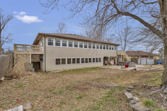 rear view of property with fence, a storage shed, an outdoor structure, a wooden deck, and stairs