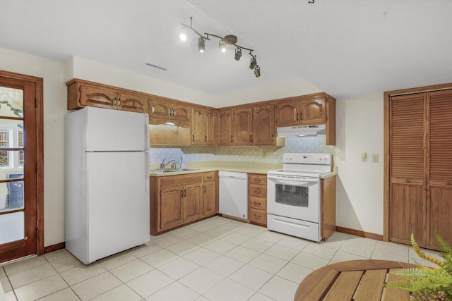 kitchen featuring white appliances, a sink, light countertops, under cabinet range hood, and tasteful backsplash