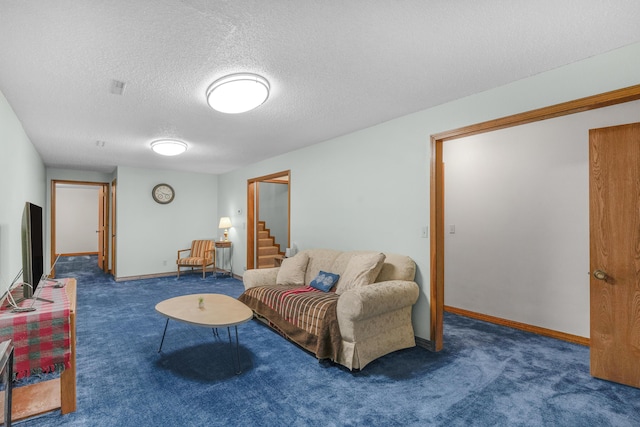 living area featuring carpet flooring, baseboards, and a textured ceiling