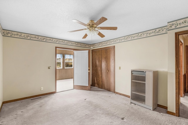 unfurnished bedroom featuring visible vents, baseboards, beverage cooler, carpet floors, and a textured ceiling