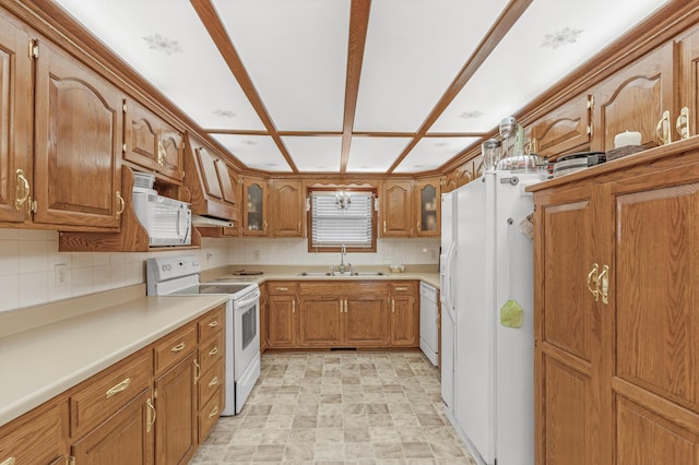 kitchen featuring backsplash, glass insert cabinets, brown cabinetry, white appliances, and a sink