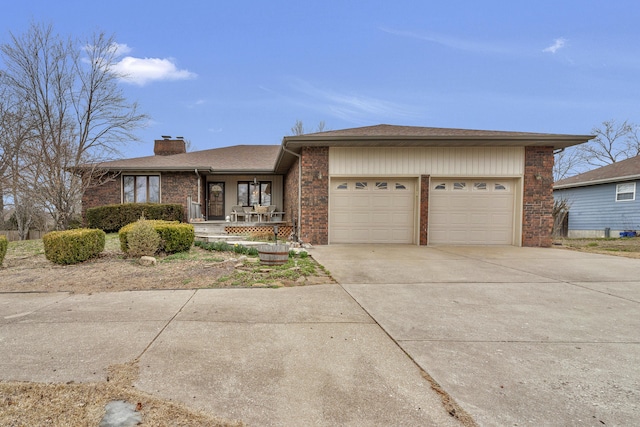 view of front of house featuring brick siding, a porch, a chimney, a garage, and driveway