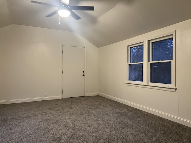 additional living space with ceiling fan, baseboards, vaulted ceiling, and dark colored carpet