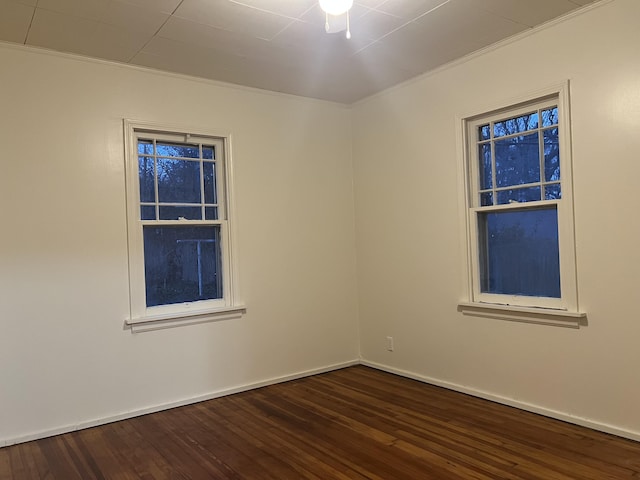 empty room featuring dark wood-style floors and baseboards