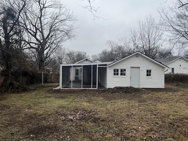 rear view of property featuring a sunroom and a yard