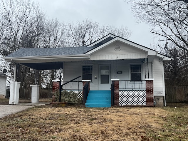 view of front of house featuring a shingled roof, a porch, and a front yard