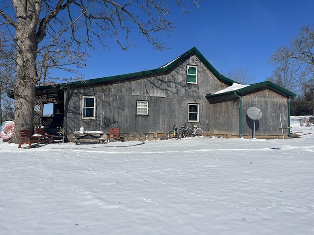 snow covered house featuring an outdoor fire pit