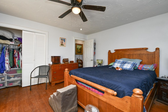 bedroom featuring dark wood-style floors, a closet, ceiling fan, and a textured ceiling