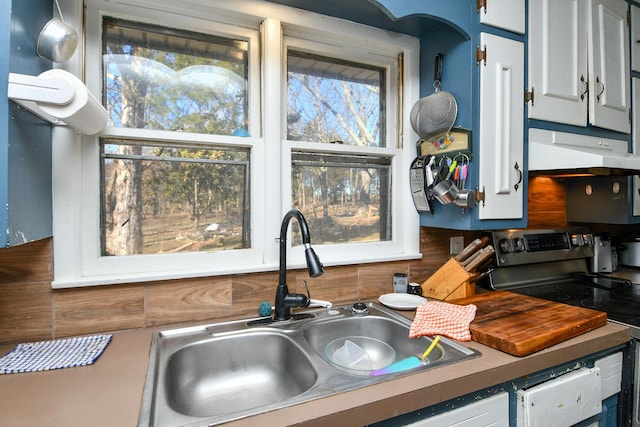 kitchen with white cabinetry, a sink, under cabinet range hood, and stainless steel electric range