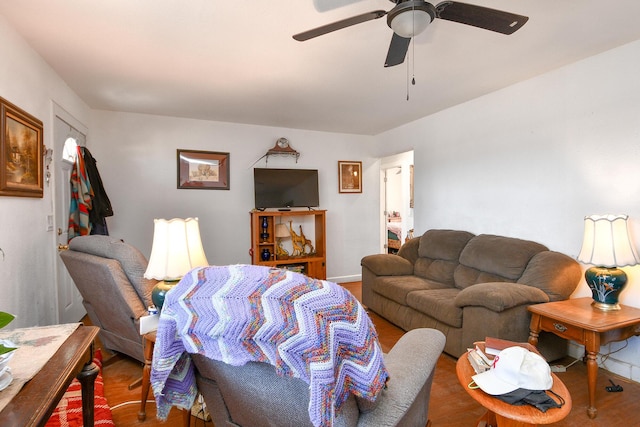 living area featuring a ceiling fan and wood finished floors